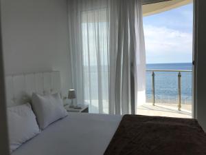 una camera da letto con un letto e vista sull'oceano di First line of the sea 1 a Dobra Voda Altre 13 foto