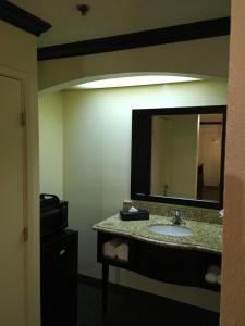 a bathroom with a sink and a large mirror at Ramada by Wyndham Ontario in Ontario