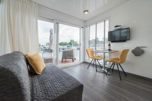 een woonkamer met een bank en een tafel met stoelen bij Boatlodge Antigua in Maastricht