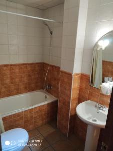 ein Badezimmer mit Badewanne und Waschbecken in der Unterkunft Hostal Restaurante El Parador in Alcaracejos + 15 Fotos