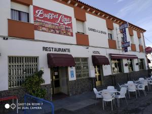 ein Restaurant mit Tischen und Stühlen außerhalb eines Gebäudes in der Unterkunft Hostal Restaurante El Parador in Alcaracejos