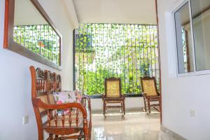 a room with rocking chairs and stained glass windows at Hotel Jardines Evans By GEH Suites in Mompos