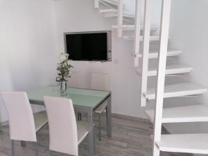 comedor con mesa verde y sillas blancas en wonderful white appartament in las Tortugas, en Arona