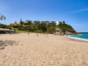 a beach with people walking on the sand and the ocean at Apa Pau Brasil in Búzios