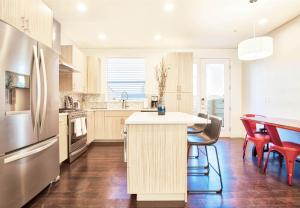 a kitchen with a table and chairs and a refrigerator at Beautiful 3 Bedroom Townhouse in Old Town North, Brewery District in Fort Collins