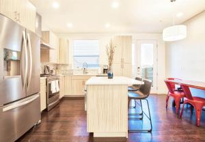 uma cozinha com uma mesa e cadeiras e um frigorífico em Beautiful 3 Bedroom Townhouse in Old Town North, Brewery District em Fort Collins