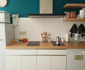a kitchen with white cabinets and a wooden counter top at Albergue O Peirao in A Guarda