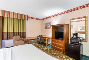 ein Hotelzimmer mit einem Bett, einem Schreibtisch und einem TV in der Unterkunft Lotus by Hotel Inn in Boise