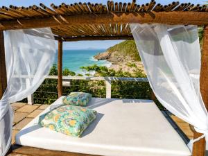 a bed in a pergola with a view of the ocean at Apa Pau Brasil in Búzios