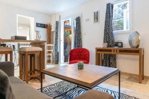 een woonkamer met een tafel en een rode stoel bij LE PATIO / les suites romantiques du grenier à sel in Honfleur