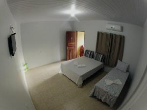 1 dormitorio con 1 cama y 1 silla en una habitación en pousada jalapão arco iris, en Mateiros