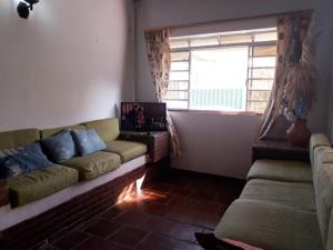 ein Wohnzimmer mit einem Sofa und einem Fenster in der Unterkunft CASA NO CENTRO DA CIDADE in Caraguatatuba