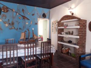 ein Esszimmer mit einem Tisch und Stühlen sowie einer Piratenwand in der Unterkunft CASA NO CENTRO DA CIDADE in Caraguatatuba