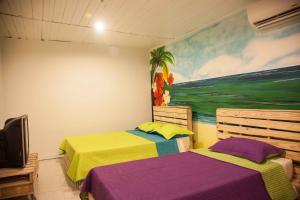 サン・アンドレスにあるApartamentos Turísticos In Di Townの壁に絵画が飾られた部屋のベッド2台
