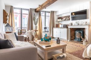 a living room with a couch and a table at LE ROMANTICA - Les Suites Romantiques Honfleur in Honfleur +22 photos