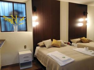 a bedroom with two beds and a window with yellow flowers at Hospedaje Ajayu Sucre in Sucre
