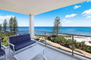 een balkon met een bank en uitzicht op de oceaan bij Kings Edge Holiday Apartments in Caloundra