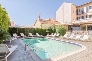 a swimming pool with lounge chairs and a house at Best Western Hotel Matisse in Sainte-Maxime