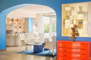 a living room with a red dresser and chairs at Best Western Hotel Matisse in Sainte-Maxime