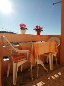 a table and chairs sitting on a balcony with the sun at Apartment Neno - 100m from the sea in Sutomišćica