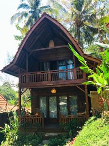 Cette grande maison en bois possède une grande fenêtre. dans l'établissement The Jungle Villa Family, à Ubud