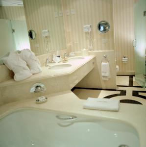 a bathroom with a tub and a sink and a mirror at The Green Park Hotel Boutique in Mexico City