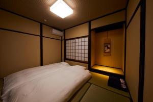a bedroom with a white bed and a light at Rinn Tsukinuke in Kyoto