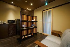 a living room with a bed and a table and a room at Rinn Tsukinuke in Kyoto