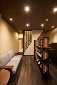 a living room with a couch and a shelf with shoes at Rinn Tsukinuke in Kyoto