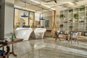 a lobby of a hotel with a reception desk and chairs at Sofiana My Khe Hotel & Spa- Rooftop Pool Bar in Danang