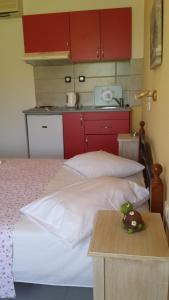 a bedroom with a bed with red cabinets and a table at Eva Apartments in Svoronata
