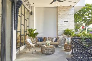 a patio with chairs and tables on a building at Sofiana My Khe Hotel & Spa- Rooftop Pool Bar in Danang
