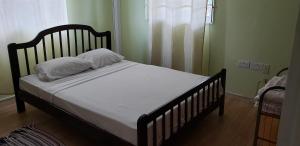 Una cama con sábanas blancas y almohadas en un dormitorio. en Unit 2 Private Apartment - Roseau, en Roseau