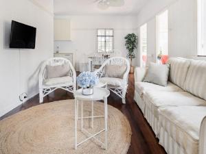 sala de estar con sofá blanco y sillas en Lake Weyba Noosa Lodge & Kangaroos en Peregian Beach