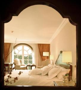 a bedroom with a large white bed with a large mirror at The Green Park Hotel Boutique in Mexico City