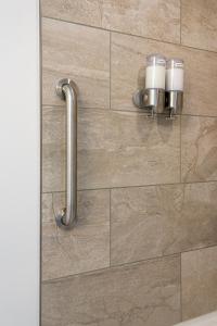 a bathroom with a wall with two cups on it at Adela's Bed and Breakfast in West Kelowna