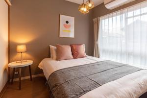 sypialnia z dużym łóżkiem i oknem w obiekcie Bijou Suites Pieces w Osace