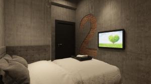 a bedroom with a bed and a tv on a wall at Brown Hotel in George Town