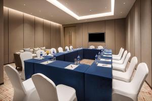 a conference room with a blue table and white chairs at Somerset IOC Hangzhou in Hangzhou