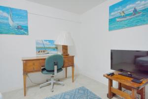 an office with a desk and a chair and a television at Hillcrest in Nassau