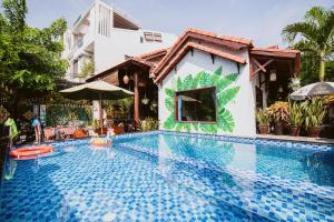 a swimming pool in front of a house at Tue Tam Garden Villa in Hoi An