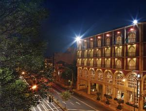 un gran edificio con luces por la noche en The Green Park Hotel Boutique, en Ciudad de México