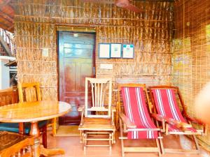 a room with chairs and a table and a door at Malayalam Lake Resort in Alleppey