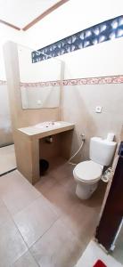 a bathroom with a toilet and a sink at Bali Bhuana Beach Cottages in Amed