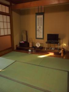 Zimmer mit einem grünen Teppich und einem Tisch in der Unterkunft Hagurokan in Tsuruoka