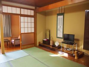 a room with a living room with a television at Hagurokan in Tsuruoka