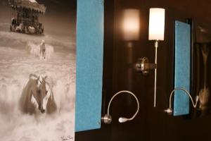 a bathroom with a picture of a horse and a light at The Dylan Hotel at SFO in Millbrae