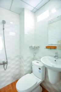 La salle de bains blanche est pourvue de toilettes et d'un lavabo. dans l'établissement My Hotel, à Quy Nhơn