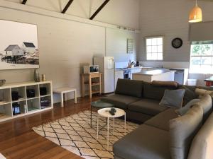 a living room with a couch and a kitchen at The Old Coolstore - Braeburn Apt in Merricks North