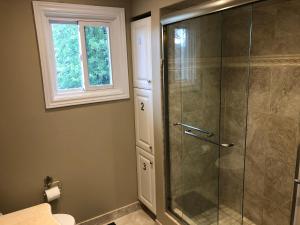 a bathroom with a shower with a glass door at Comfort Rooms near Toronto Airport in Mississauga
